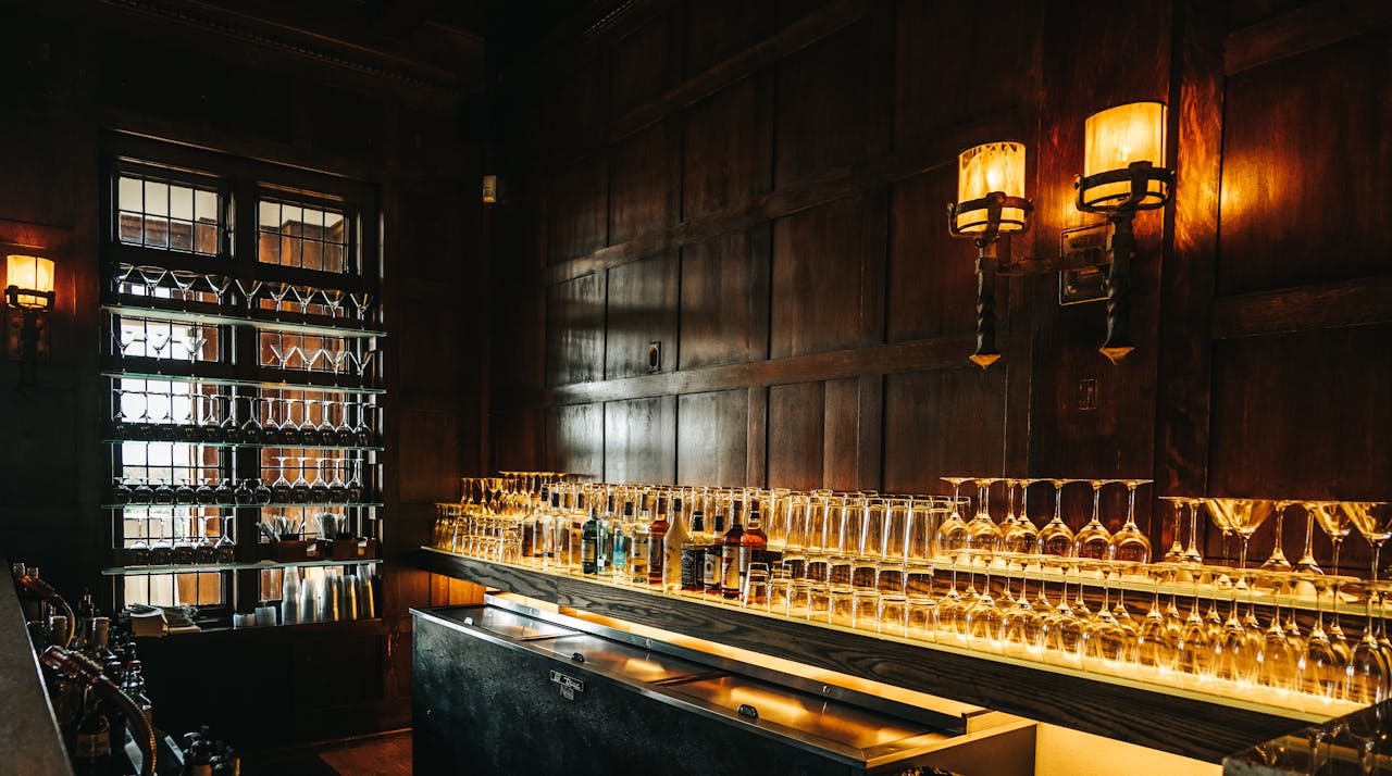 Glassware and Alcohol Bottles on the Counter at the Bar